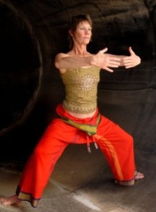 Woman in Asian Yoga Qigong influenced pose in a rust cylinder.